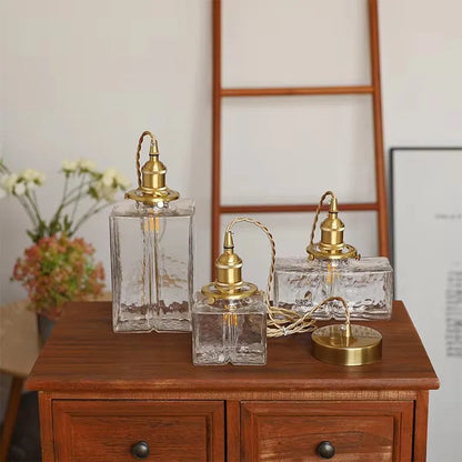 Textured glass shades and brass-finish fittings arranged on a sideboard