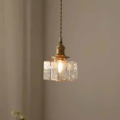 Illuminated square textured glass pendant against a wall