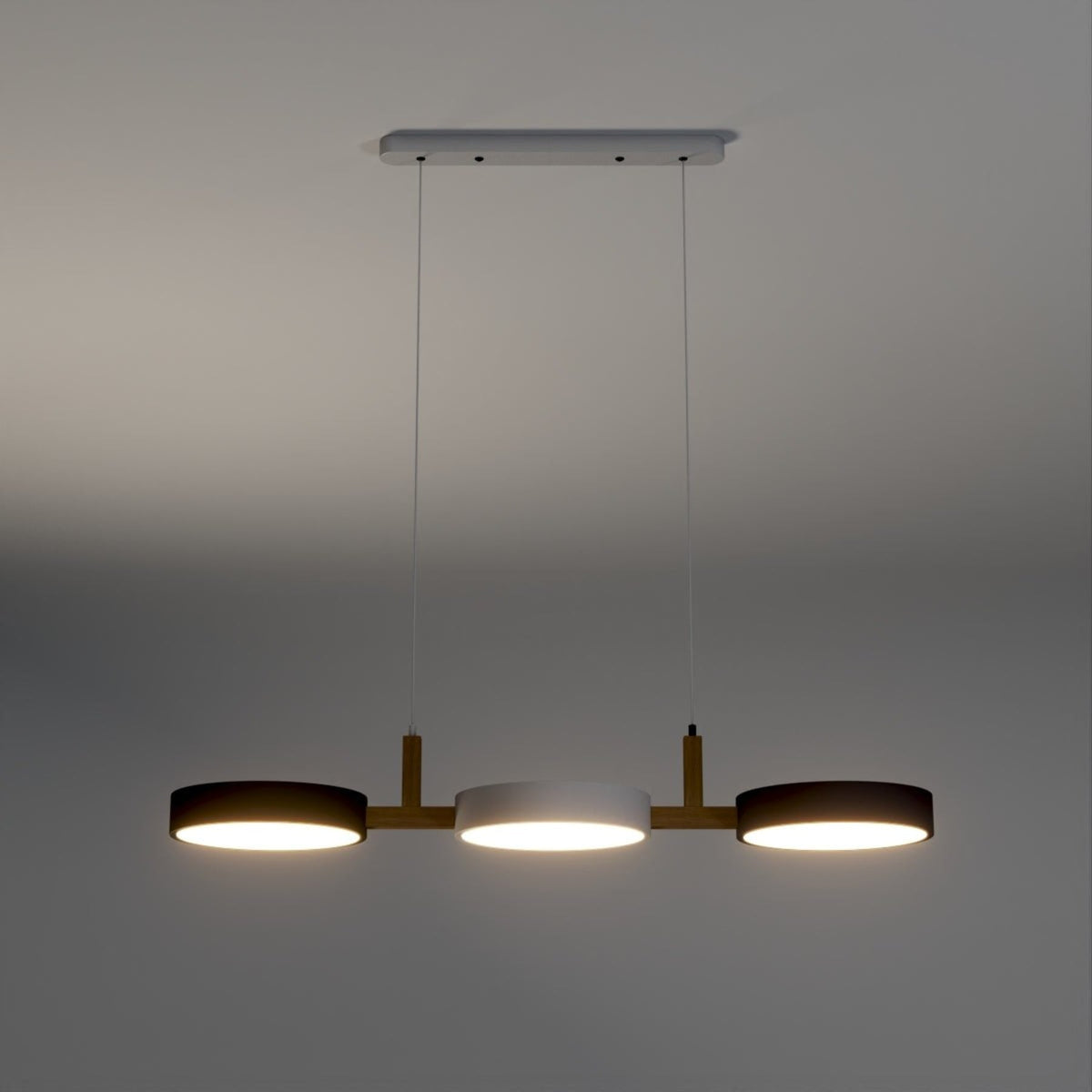 Three-disc pendant illuminated against a grey background