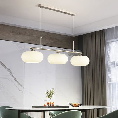 Three-light glass pendant above a kitchen island