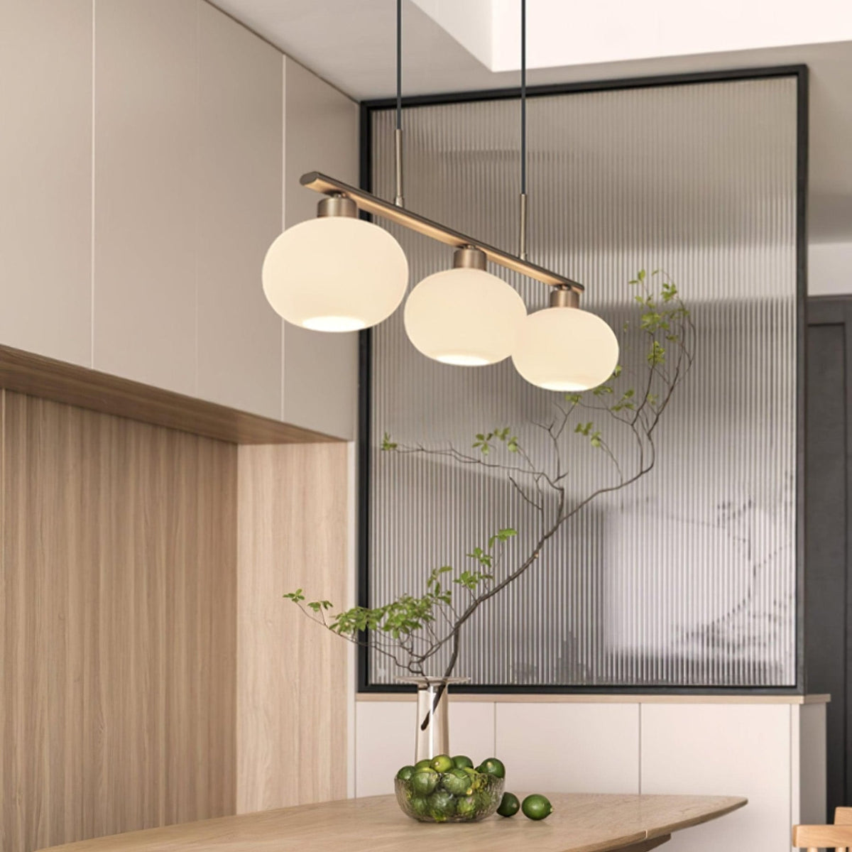 Three-light glass pendant above a kitchen island