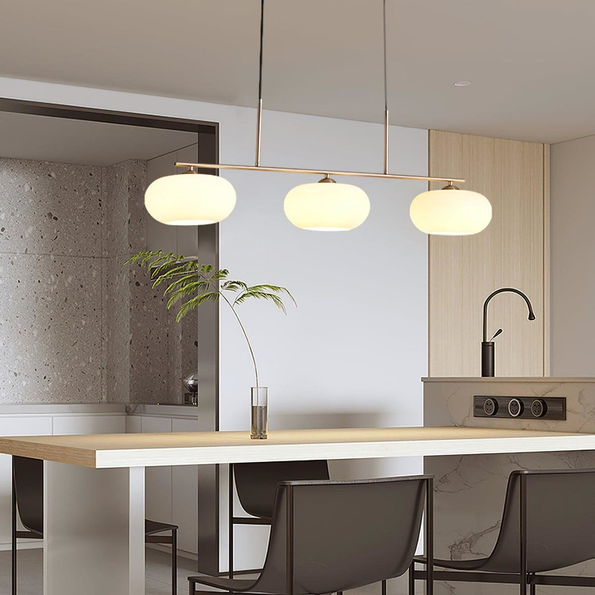 Three-light glass pendant above a kitchen island