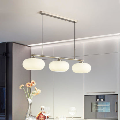 Three-light glass pendant above a kitchen island