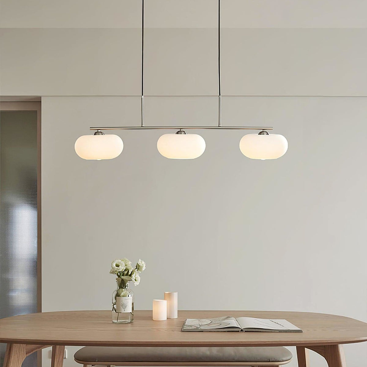 Three-light linear glass pendant in a dining room
