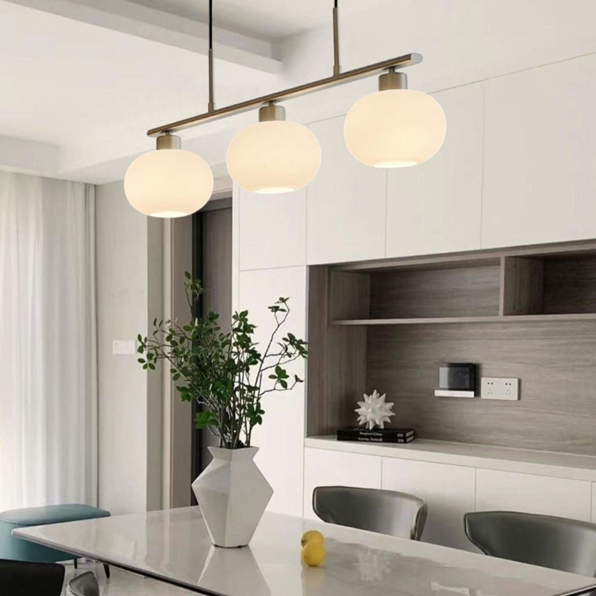 Three-light glass pendant above a kitchen island