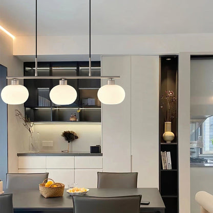 Three-light glass pendant above a kitchen island