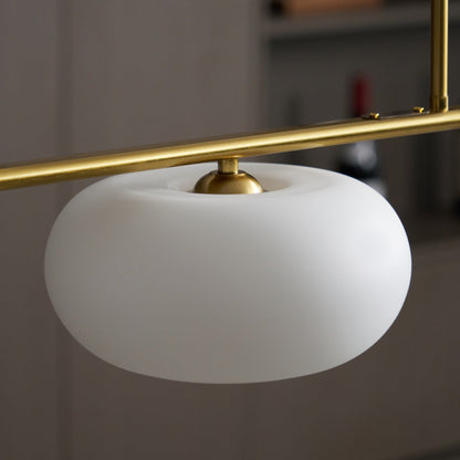 Close view of white glass shade and gold-finish pendant frame