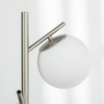 Silver tone three-light tree floor lamp with glass globe shades — close-up of shade and metal arm