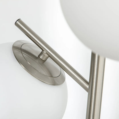 Silver tone three-light tree floor lamp with glass globe shades — close-up of shade and metal arm