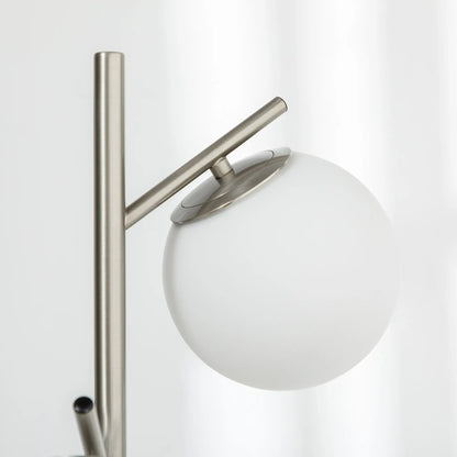 Silver tone three-light tree floor lamp with glass globe shades — close-up of shade and metal arm