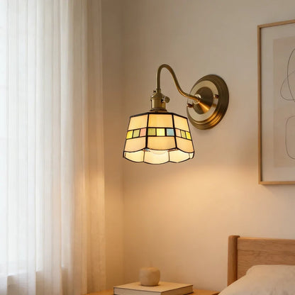 Tiffany-style glass wall light beside a bed