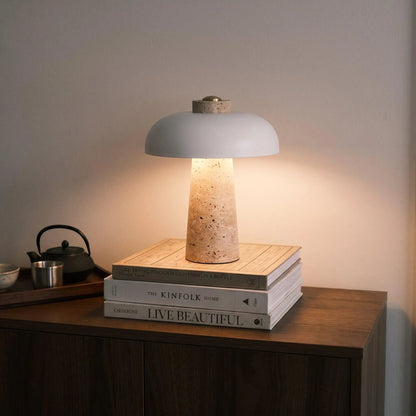 White dome shade lamp with travertine base on books