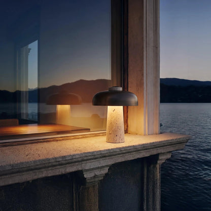 Black dome travertine lamp beside a window