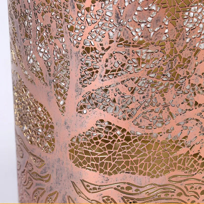 Close-up of the intricate Tree of Life cutout pattern on a copper-coloured metal solar lantern, showing the detailed filigree design.