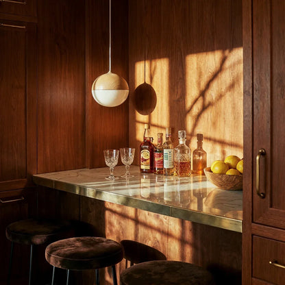 Two-tone globe pendant above a bar counter in a timber-panelled room