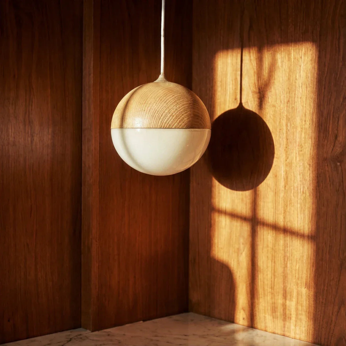 Close-up of globe pendant with textured upper shade and white glass diffuser