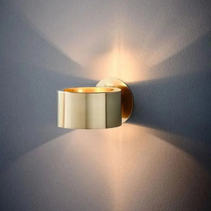 Gold drum wall light casting up-and-down beams