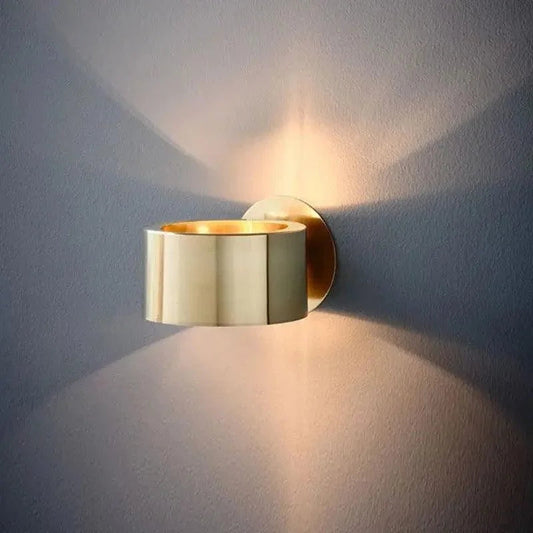 Gold drum wall light casting up-and-down beams