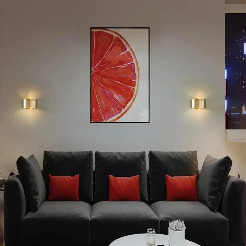 Pair of gold drum lights beside a wall picture