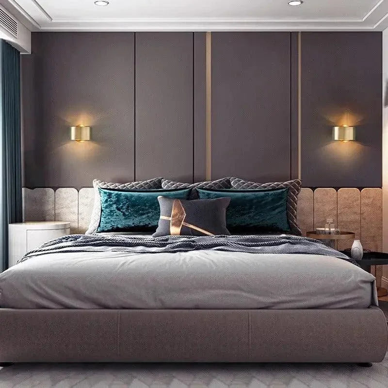 Pair of gold drum wall lights beside a bed