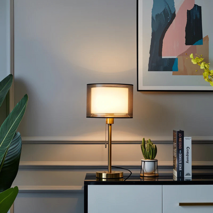 Bronze vintage table lamp with a transparent double fabric shade on a side table