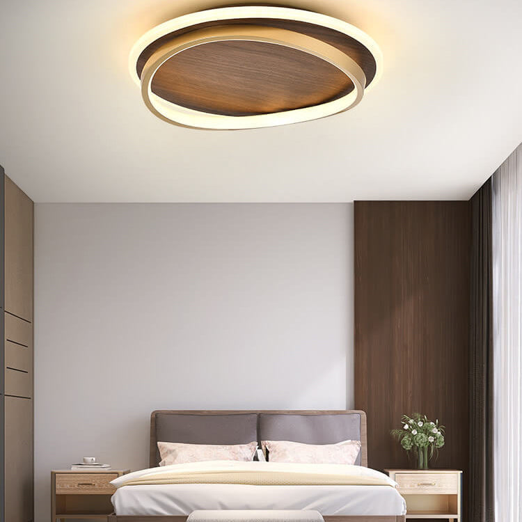 Round walnut-finish ceiling light above a bed