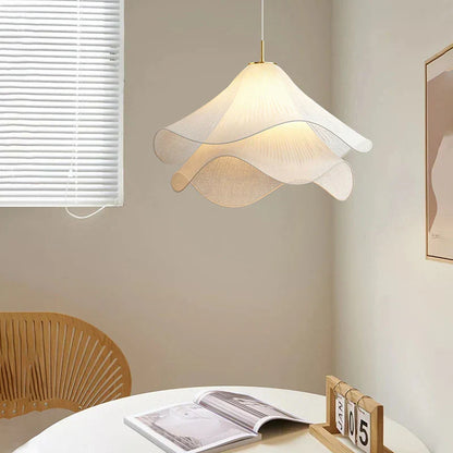 Illuminated wavy pendant beside a chair