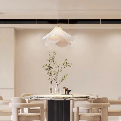 White wavy fabric pendant above a dining table