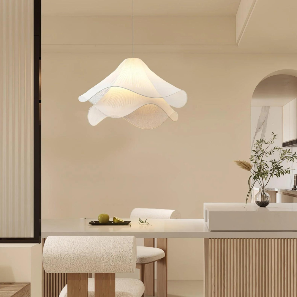 Illuminated fabric pendant above a dining area