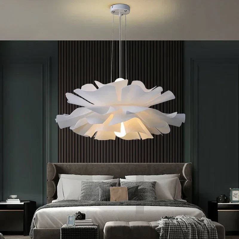 White lotus flower pendant light above a bed