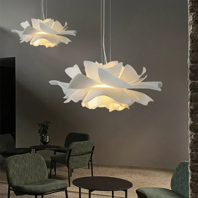 Layered white flower pendant lights over a dining area