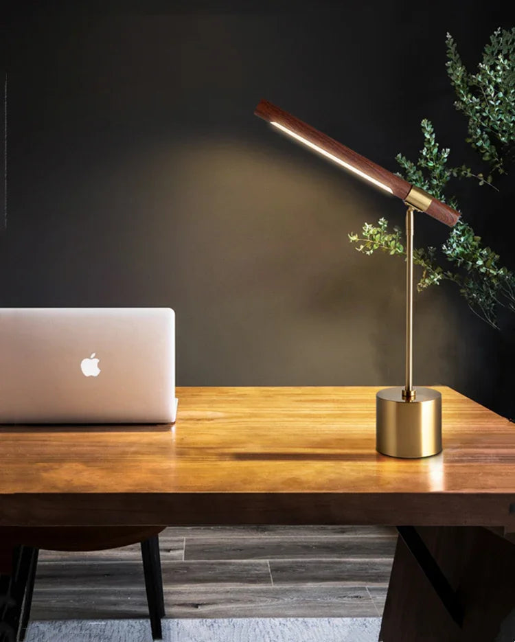 Adjustable wood LED table lamp beside a laptop
